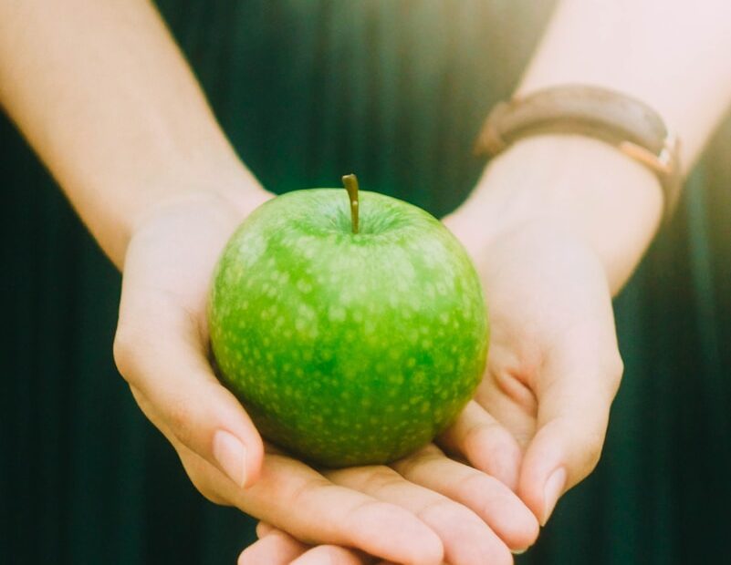 person holding green apple